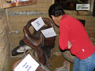 Visitante lendo informações sobre o Silhão, peça de montaria feminina, exposto no Rancho do Tropeiro em 2010.